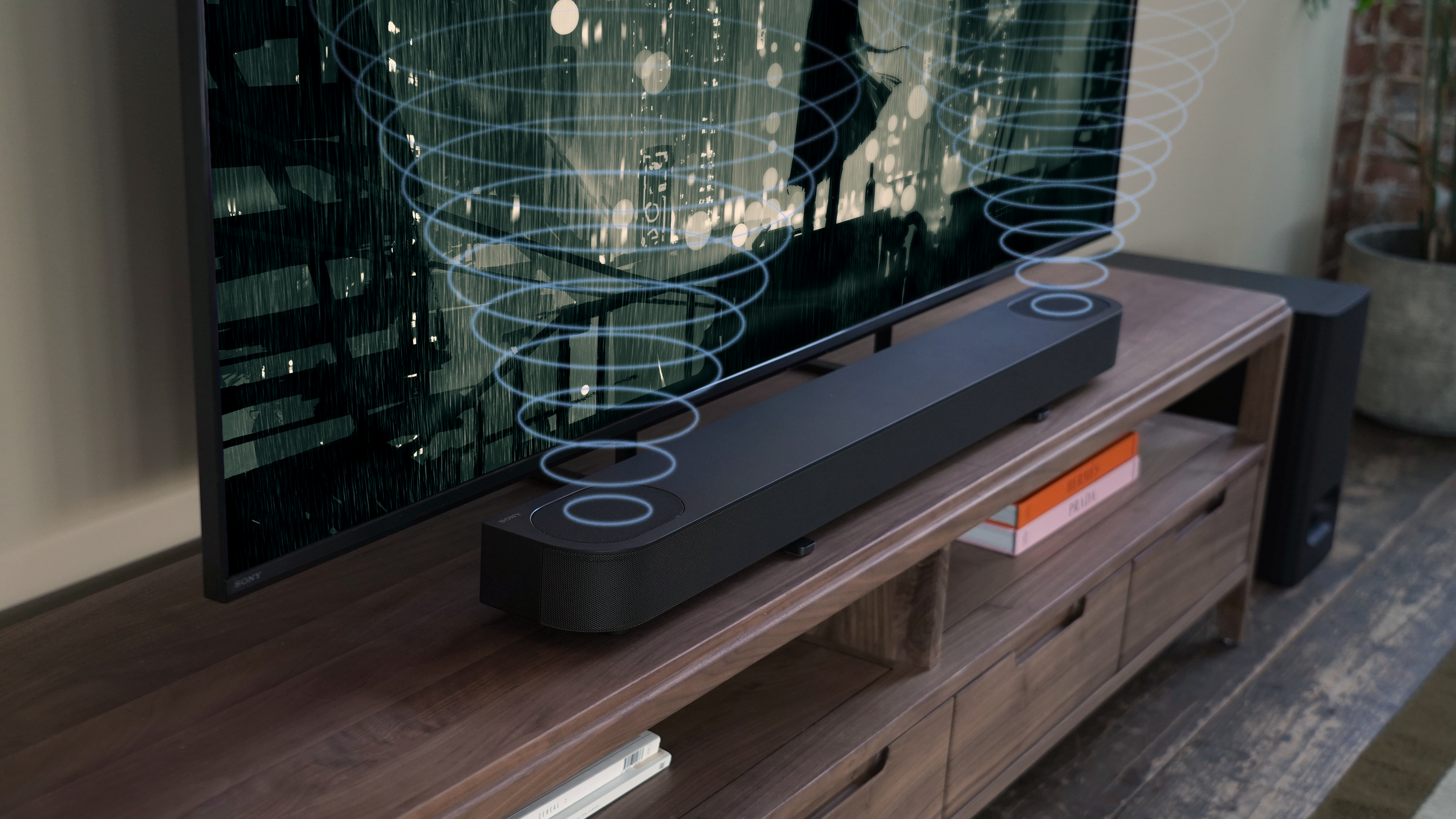 Soundbar auf Holzschrank, TV zeigt Stadtansicht.