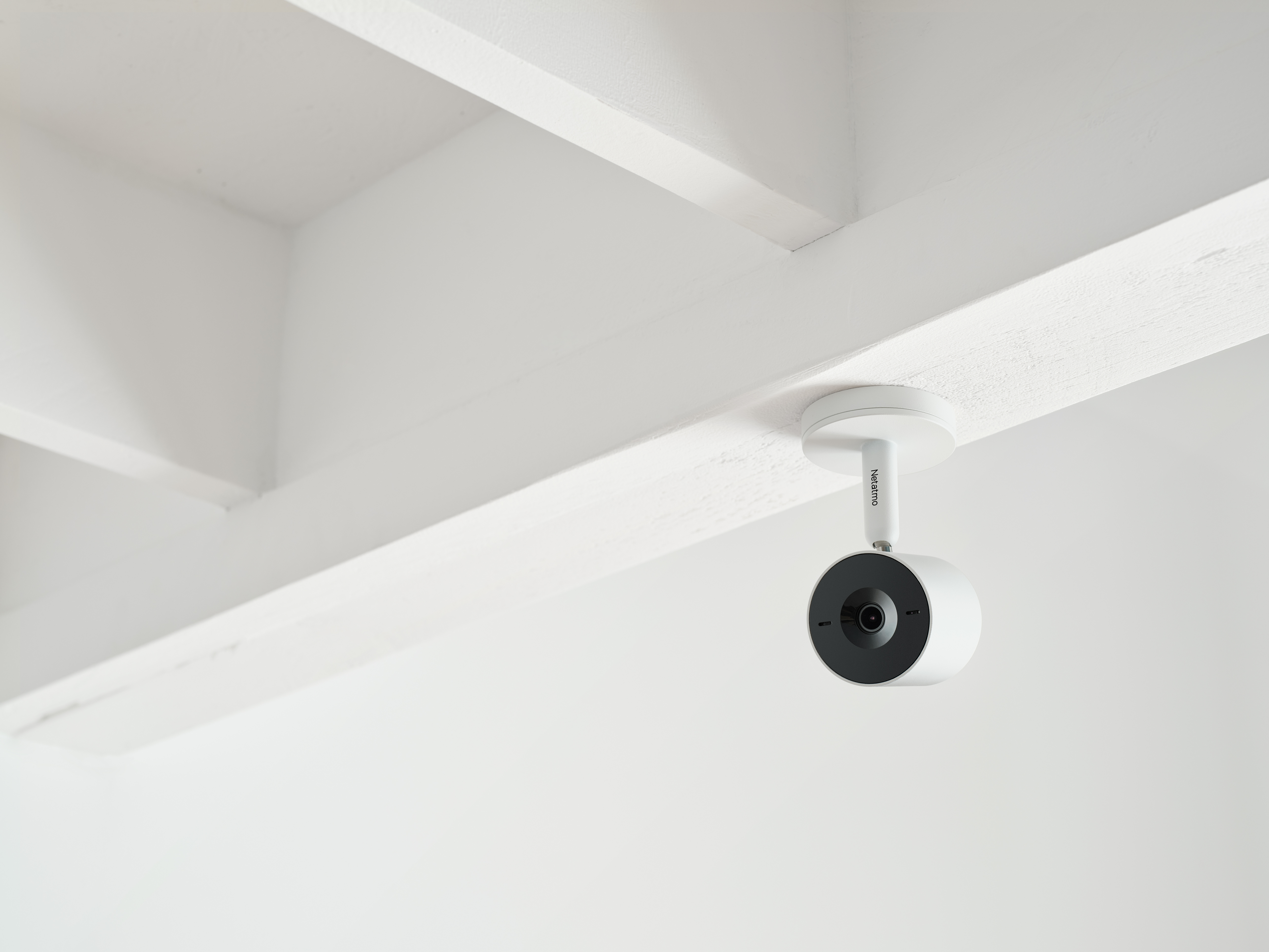 Eine weiße Überwachungskamera ist an einer weißen Decke montiert. Die Kamera ist schwarz.