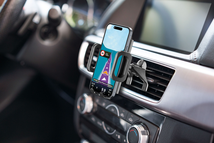 Ein Telefon, das an der Lüftung eines Autos befestigt ist und eine Navigations-App mit Route und Geschwindigkeitsbegrenzung anzeigt.