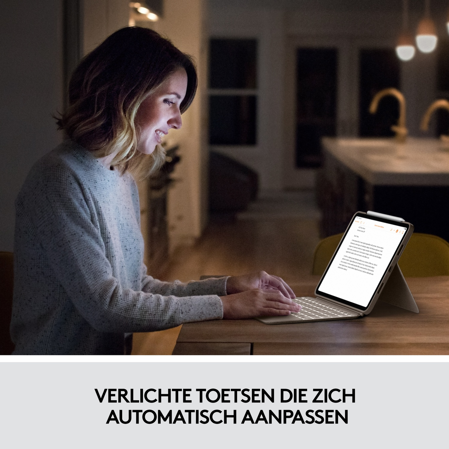 Woman using a tablet with a keyboard in a dimly lit room.