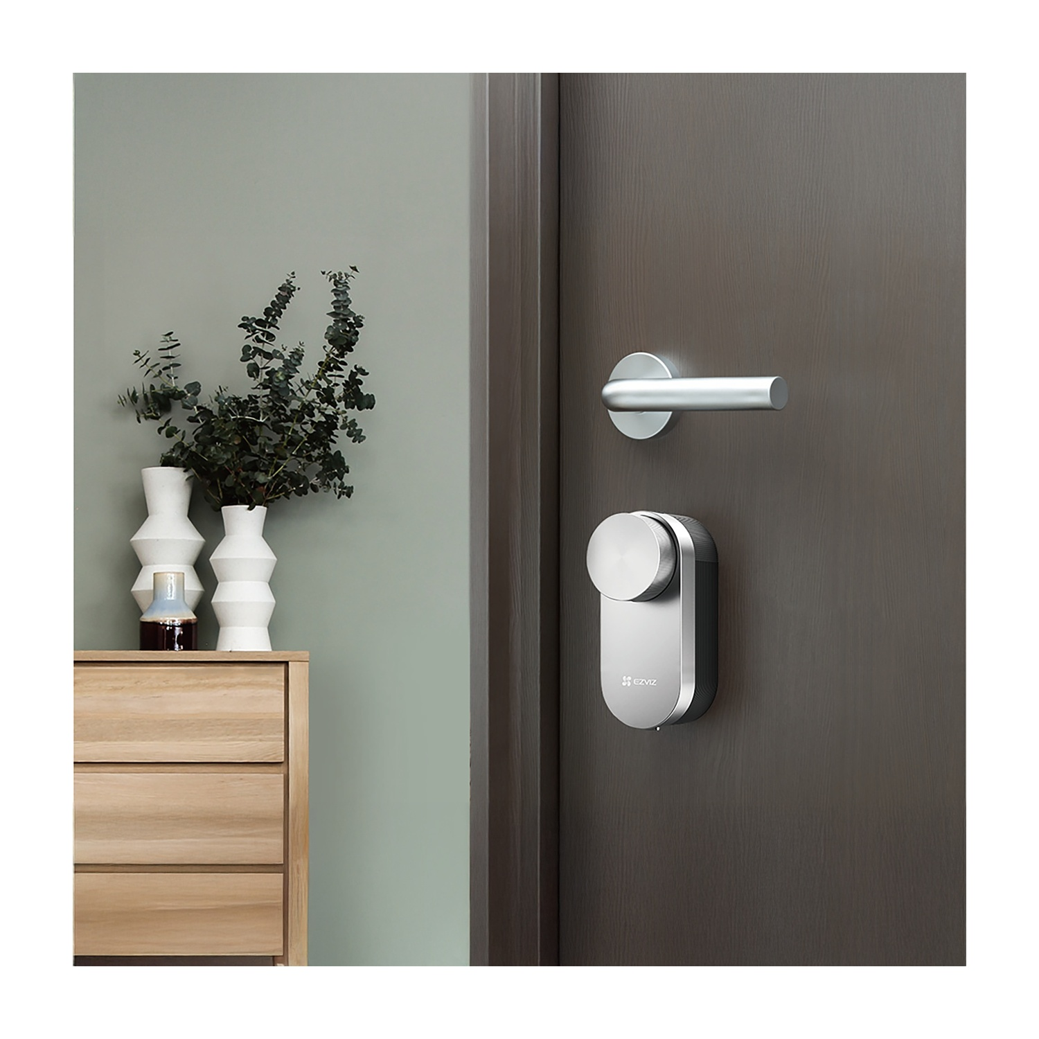 Una serratura intelligente su una porta scura. Sullo sfondo un mobile in legno con vasi.