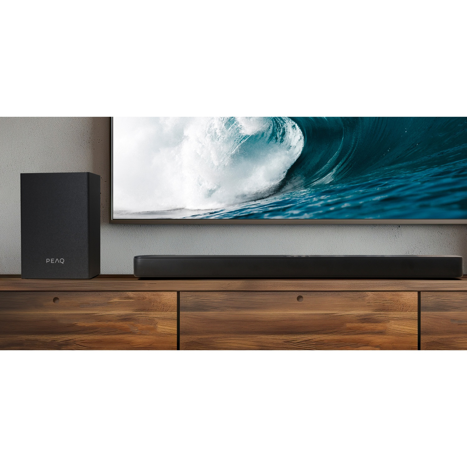 Une barre de son et un caisson de basses noirs sur un meuble en bois, avec TV.