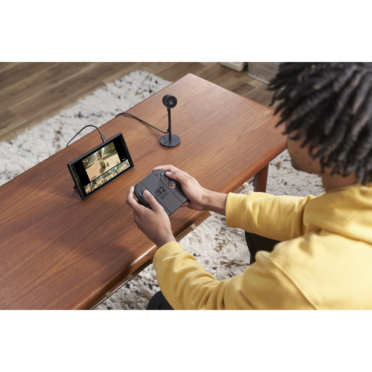 Persona che gioca su un Nintendo Switch con una fotocamera su un tavolo.