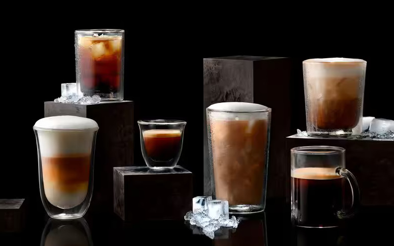 Różne napoje kawowe w przezroczystych szklankach na ciemnym tle z lodem.