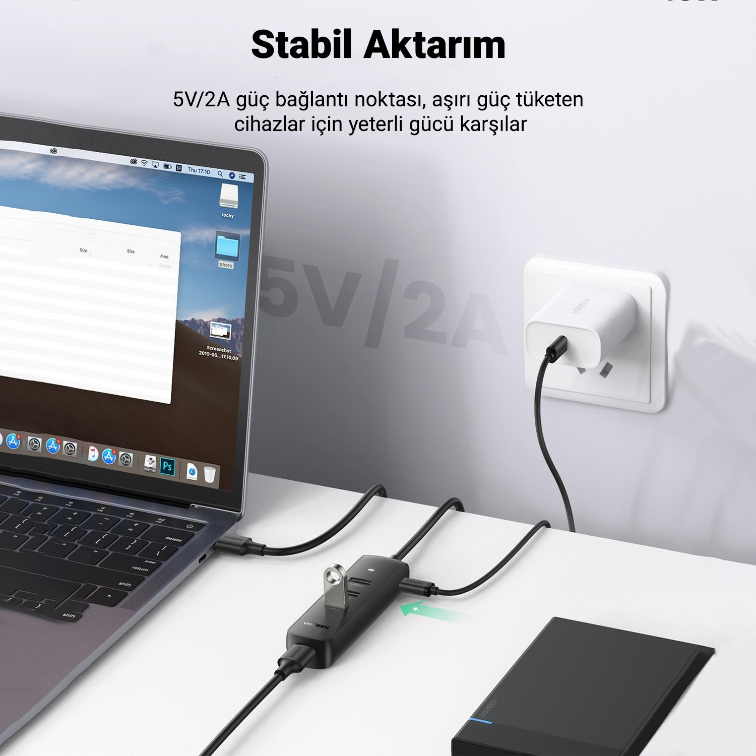 USB bağlantı noktalarına sahip bir hub'a bağlı dizüstü bilgisayar, bir dizüstü bilgisayar ve takılı bir güç adaptörü.