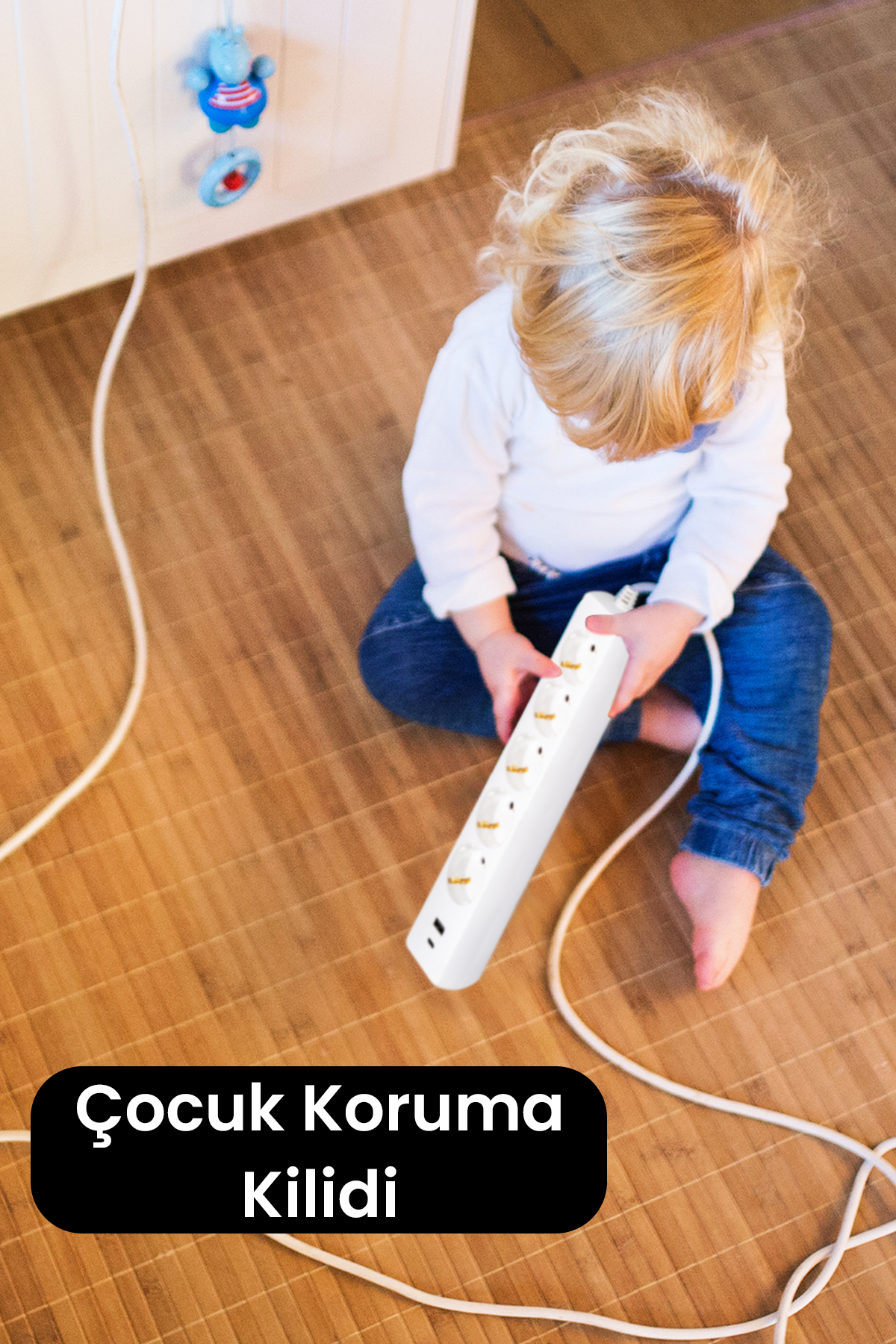 Bir uzatma kablosu ile bir çocuk. Görüntüde "Çocuk Emniyet Kilidi" metni var.