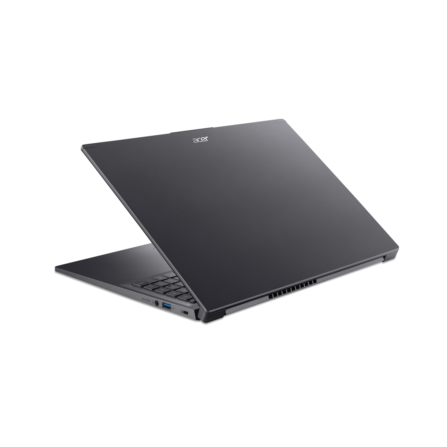 Laptop in a dark setting, open and angled, showing keyboard and screen.