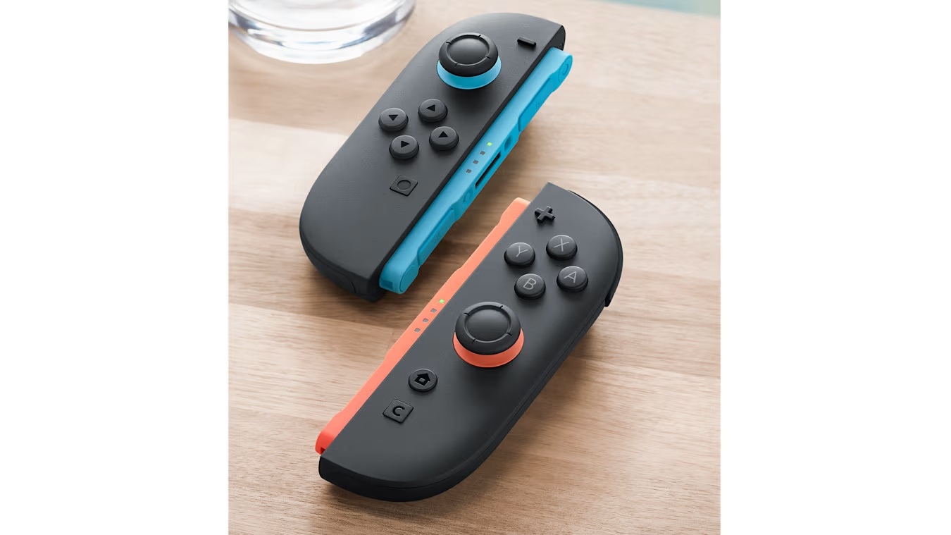 Dos mandos Nintendo Switch. Uno azul y otro rojo, sobre una superficie de madera.