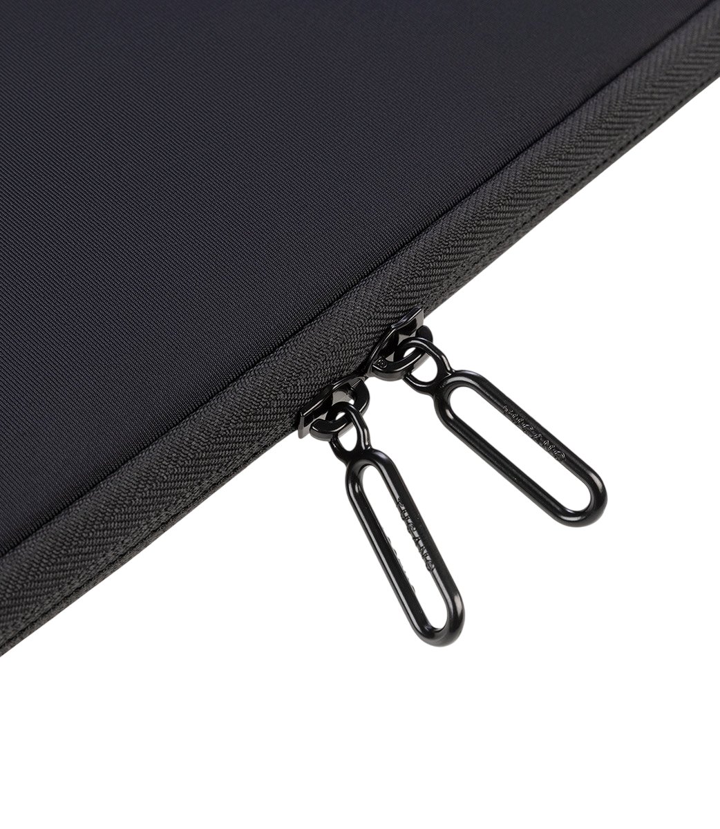 Schwarze Tasche mit zwei silbernen Reißverschlüssen und schwarzen Zuglaschen.