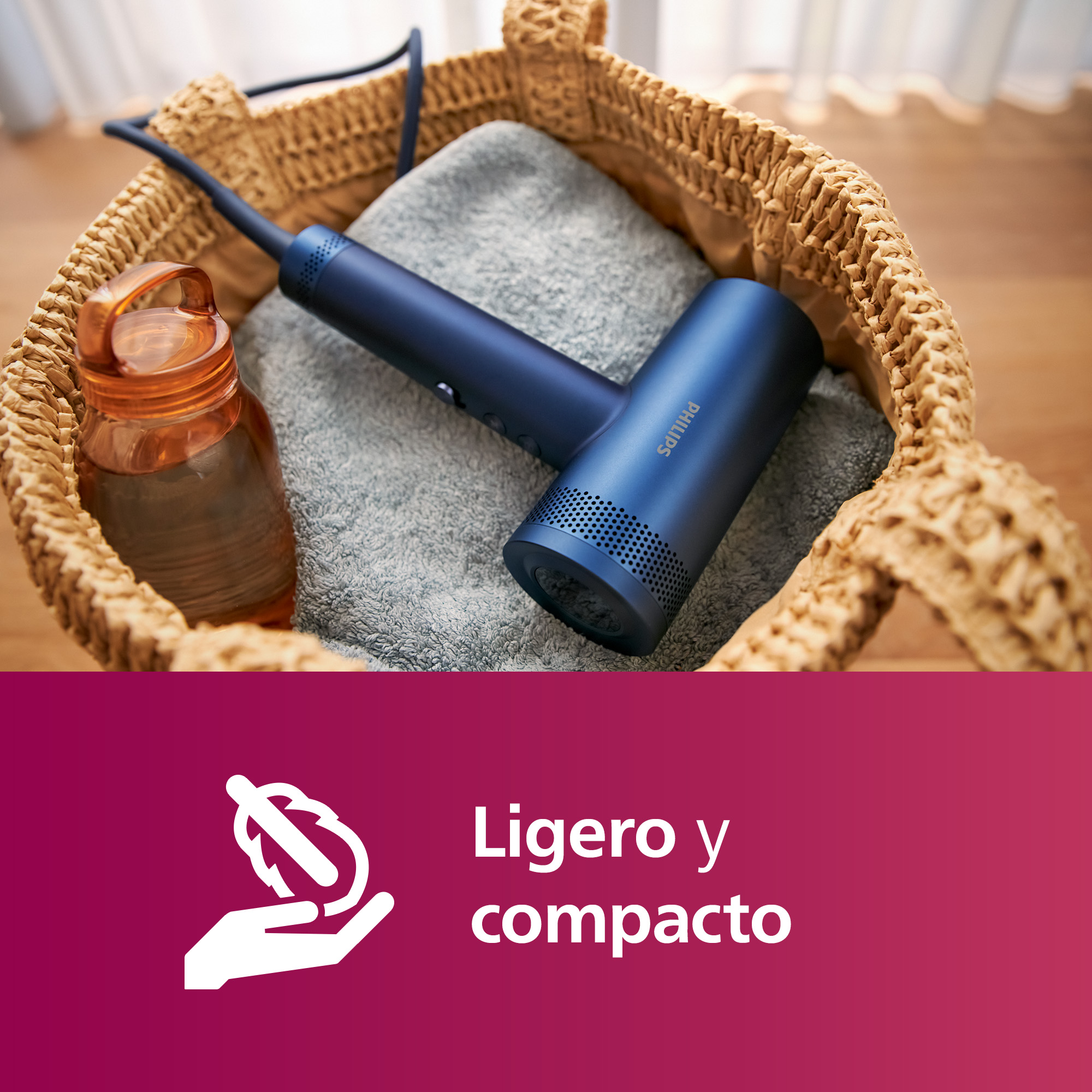 Un secador de pelo azul, una toalla y una botella en una cesta de mimbre con texto.