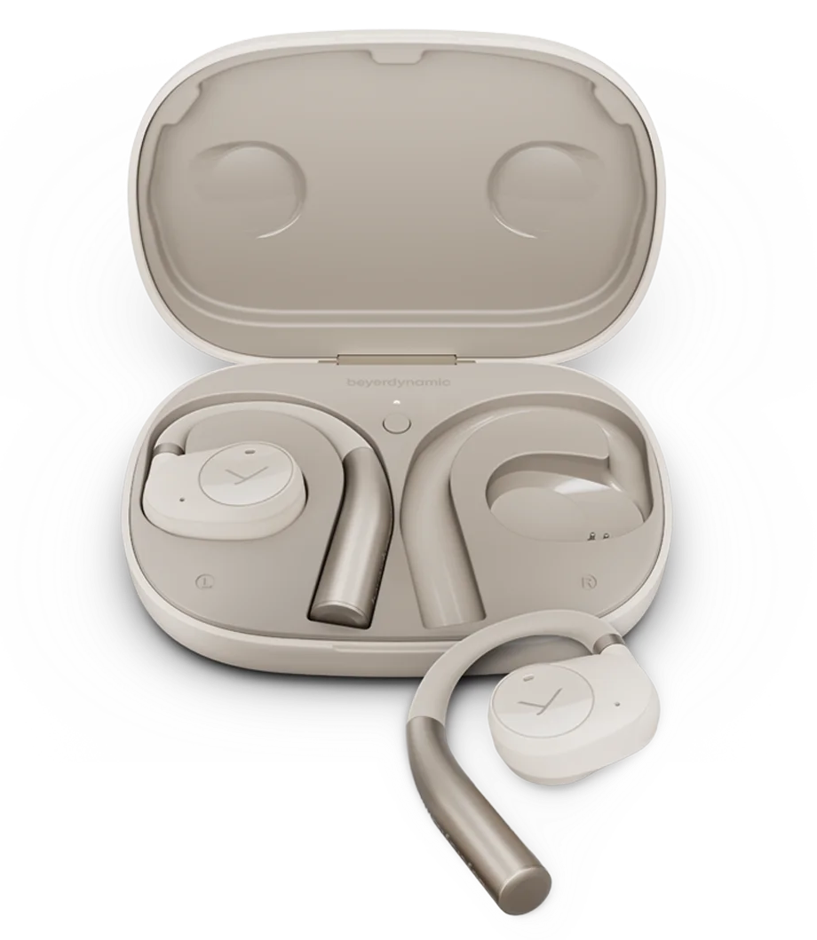 Słuchawki douszne w etui ładującym. Kolor beżowy, otwarte etui, dwie słuchawki w środku, jedna na zewnątrz.