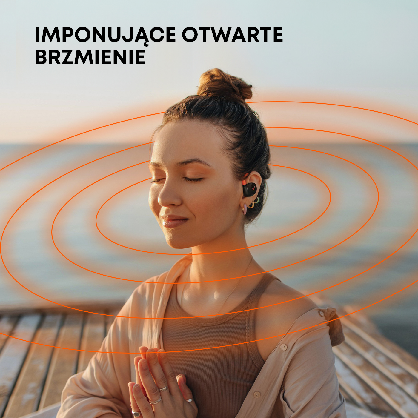 Kobieta ze słuchawkami na molo, otoczona okręgami fal dźwiękowych.
