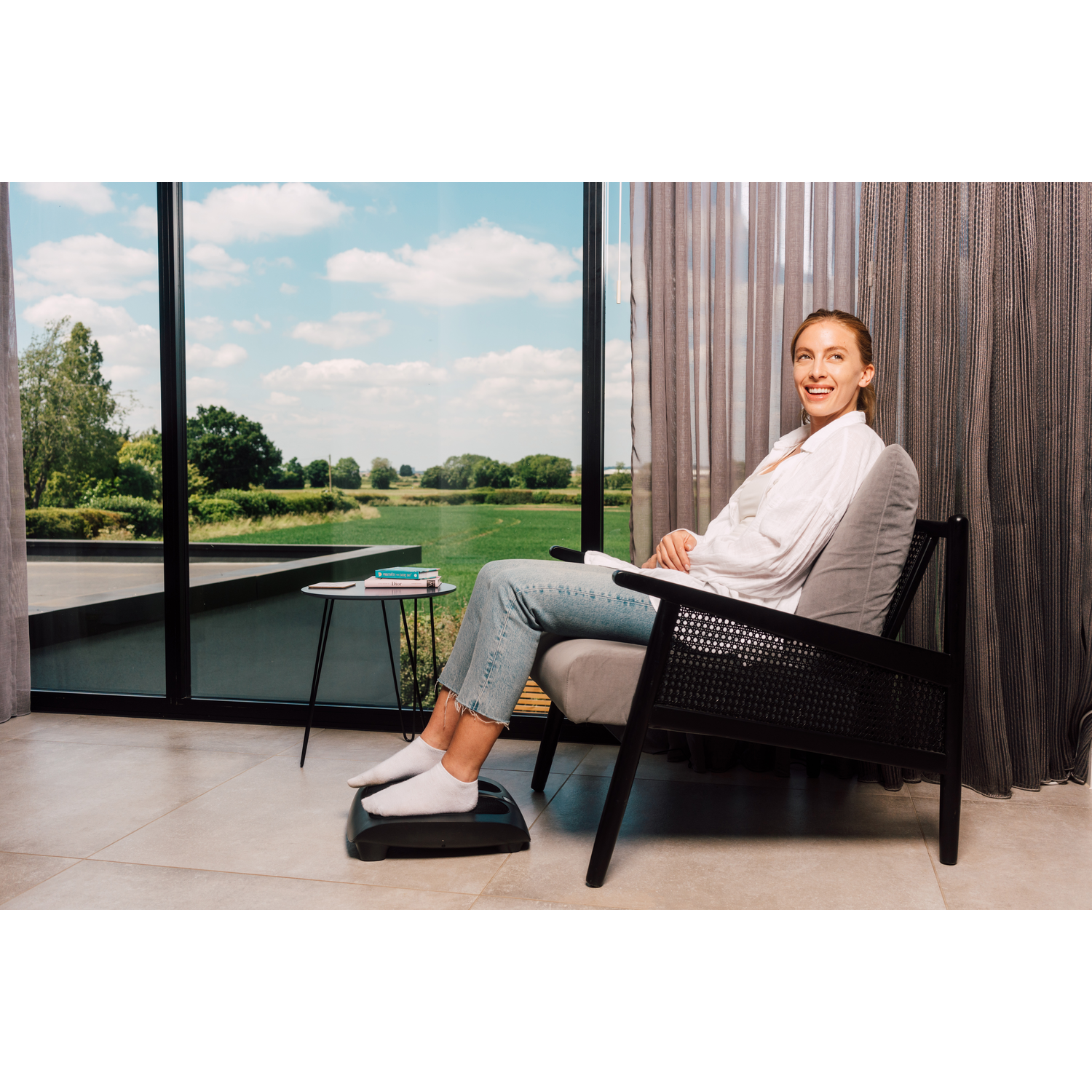Woman in a chair with footrest, looking at window.