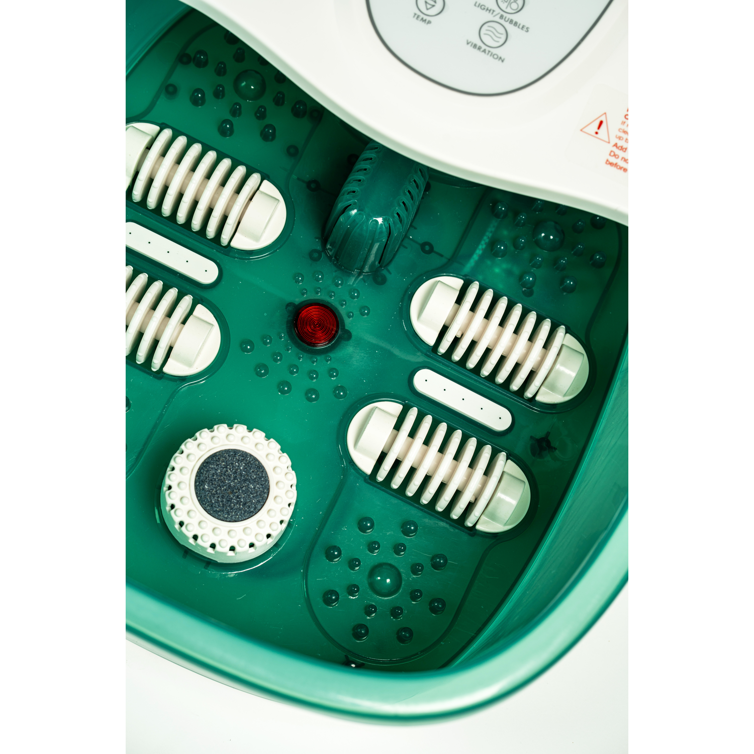 Voetspa met groen interieur. Bevat witte rollen en een rood licht. Knoppen en bedieningselementen zitten bovenop.