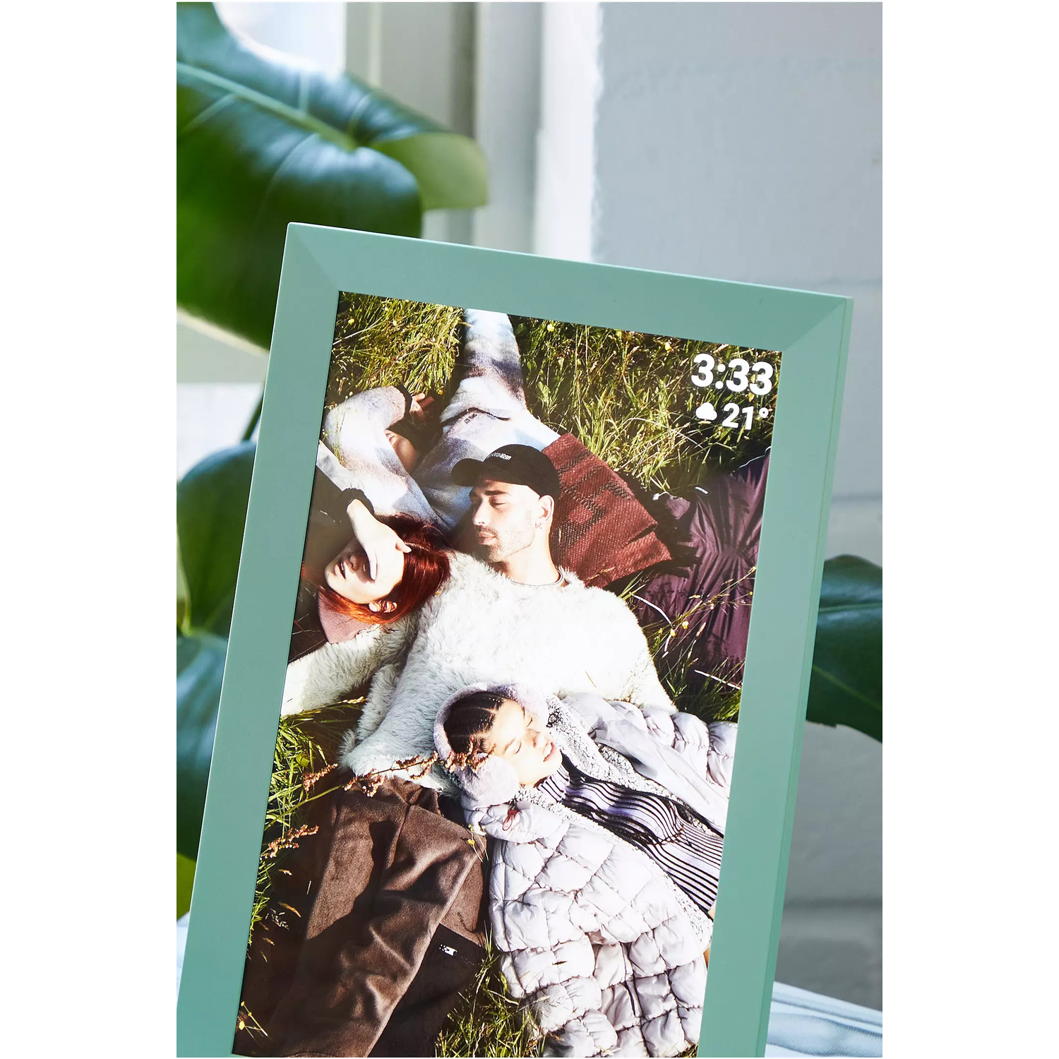 Digital photo frame displaying a photo of people in a field.