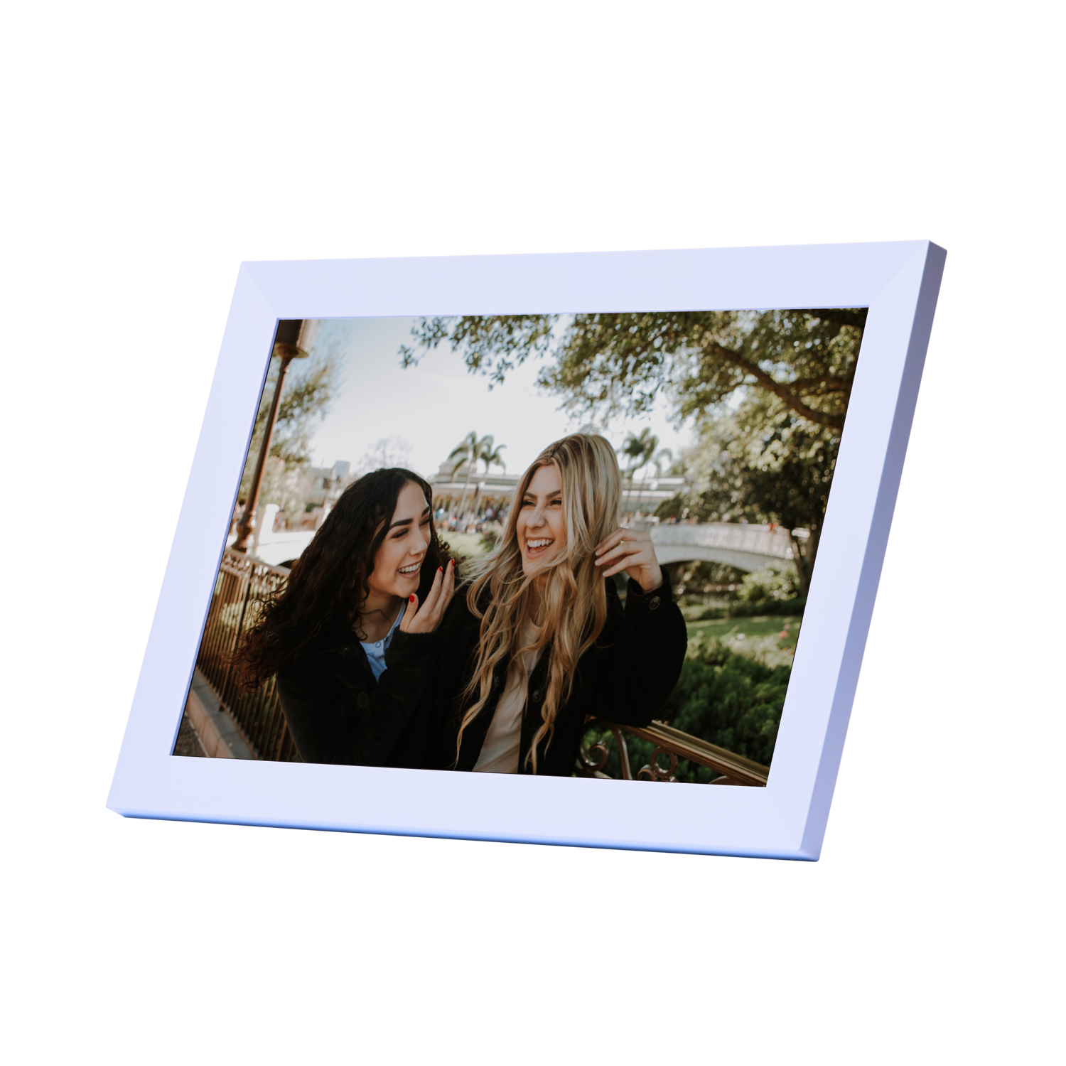 Two women laughing, in a frame leaning against a dark background. A park scene is in the background.