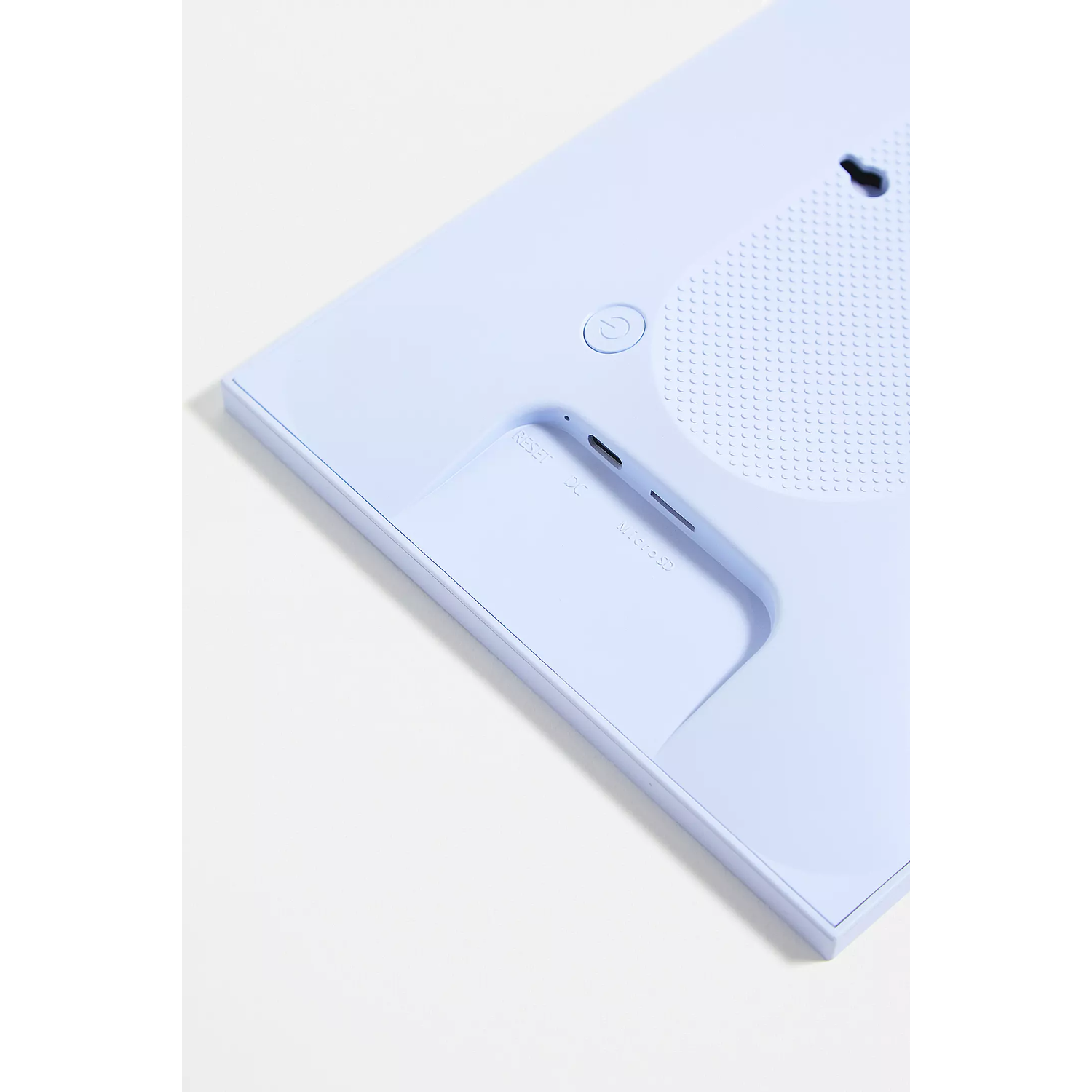 Back of a light blue device with a button, a reset port, and a USB port.