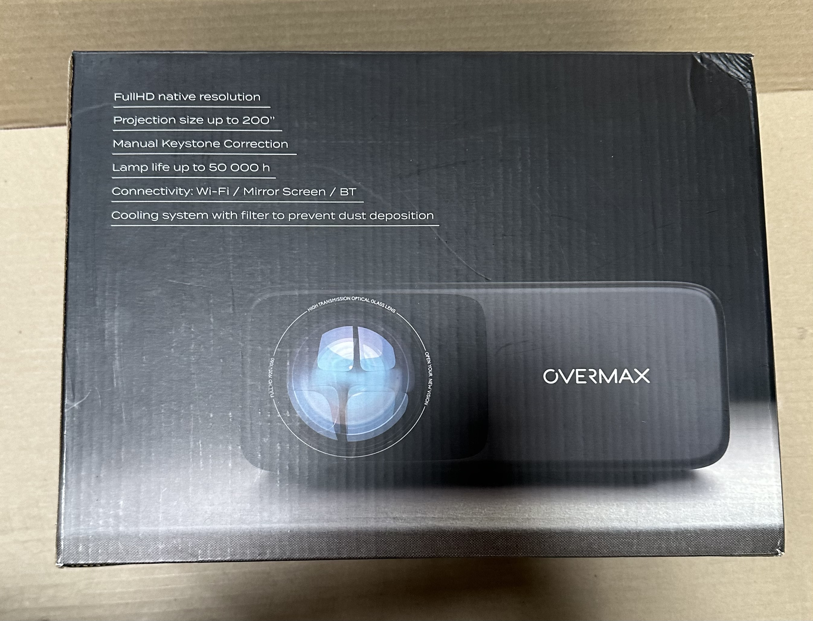 Czarne pudełko projektora ze specyfikacjami. Projektor jest widoczny. Tekst: 'OVERMAX'.