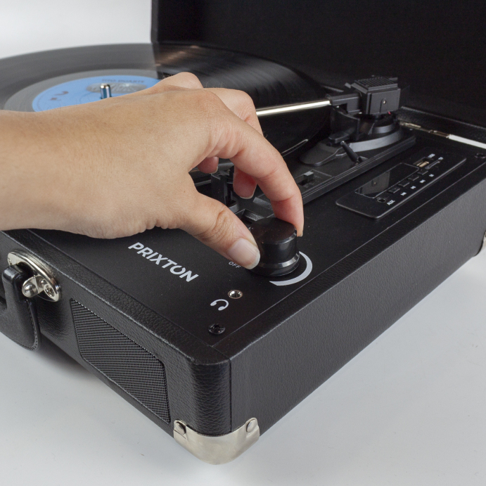 Una mano ajustando una perilla en un tocadiscos negro.