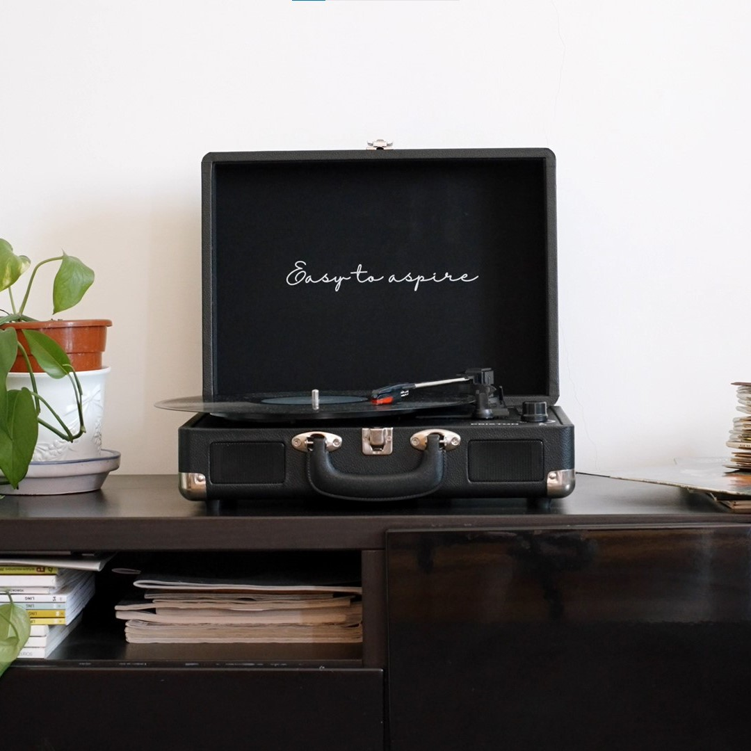 Tocadiscos negro con el texto 'Easy to aspire' dentro. Un disco está sonando.