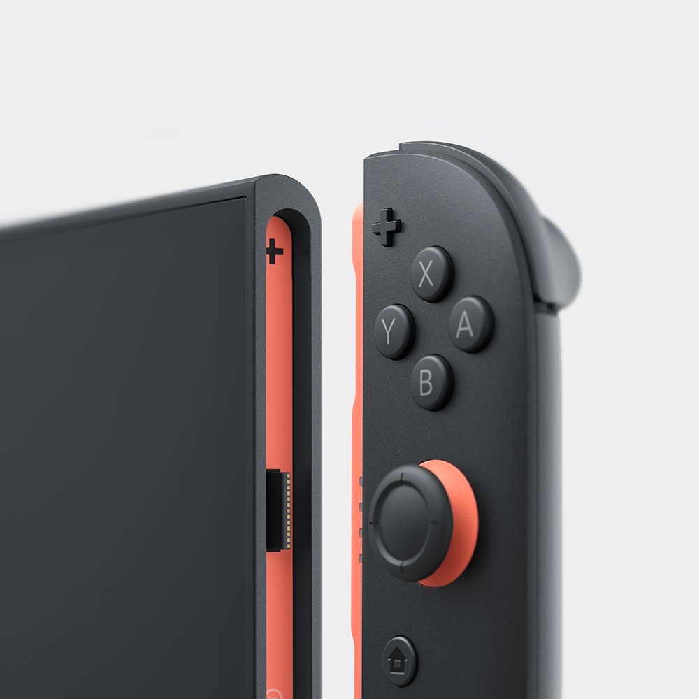 Primer plano de un controlador Nintendo Switch gris y naranja y borde de pantalla.
