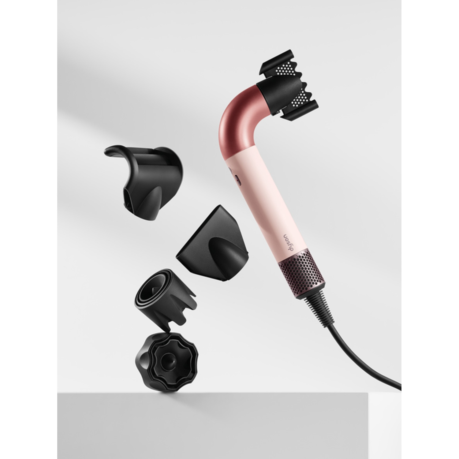 Asciugacapelli rosa e nero con ugelli staccati.