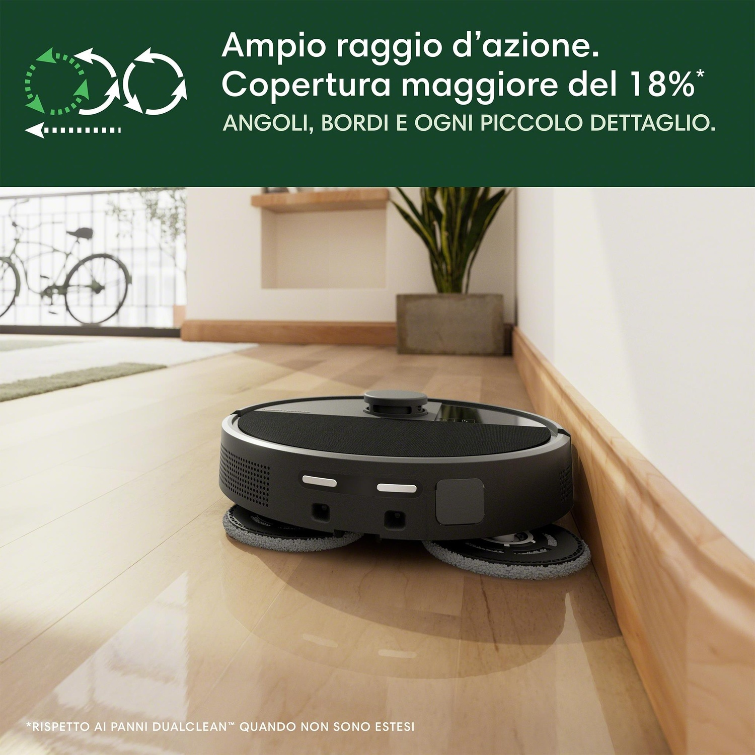 Aspirapolvere robot su pavimento in legno vicino a un muro.
