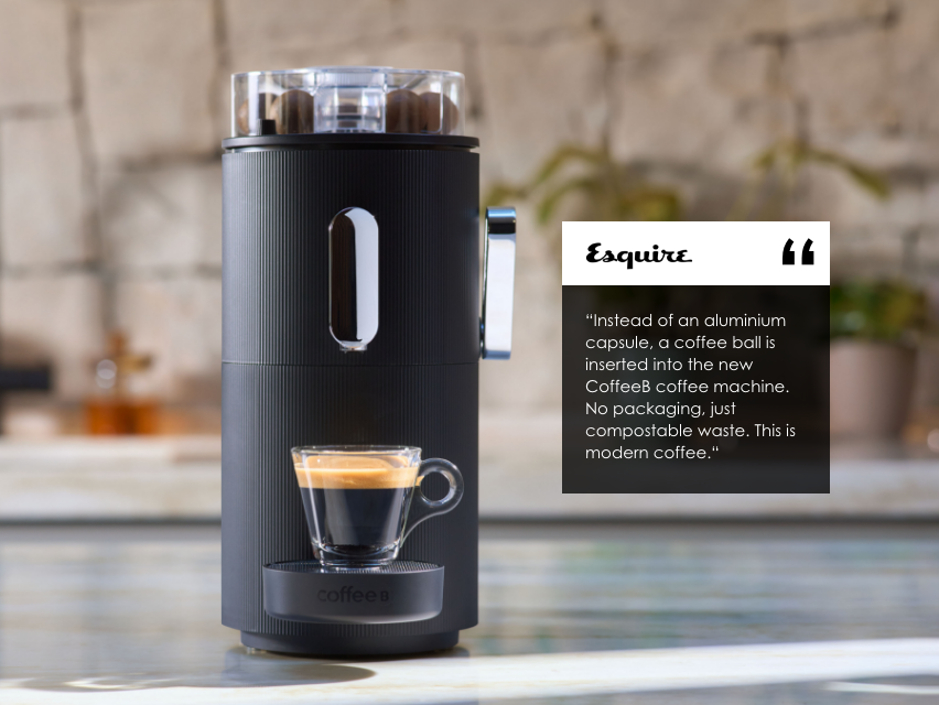 Schwarze Kaffeemaschine mit Espresso im Glas und Esquire-Zitat.