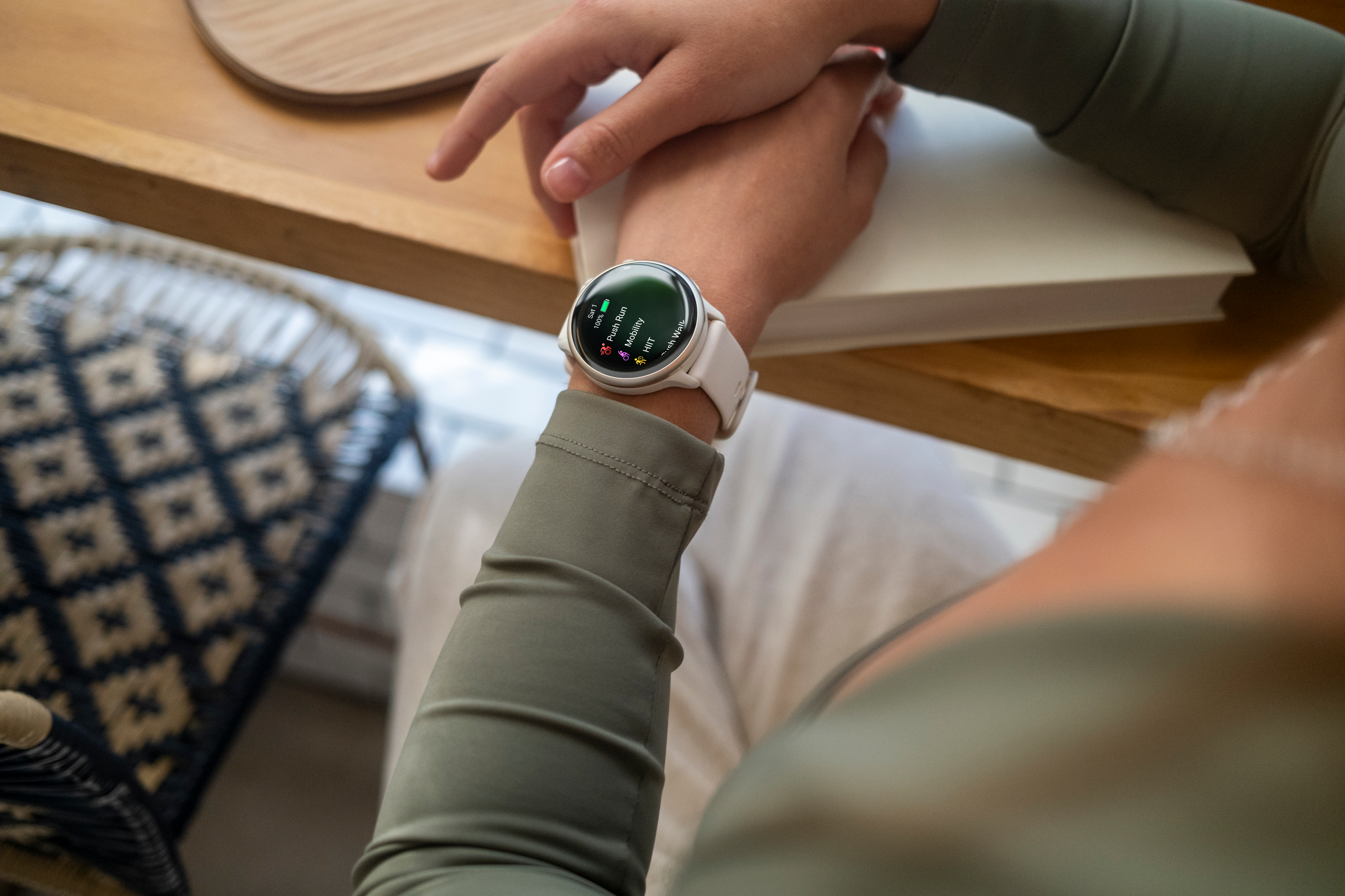 Une personne portant une smartwatch Garmin blanche, regardant son écran.