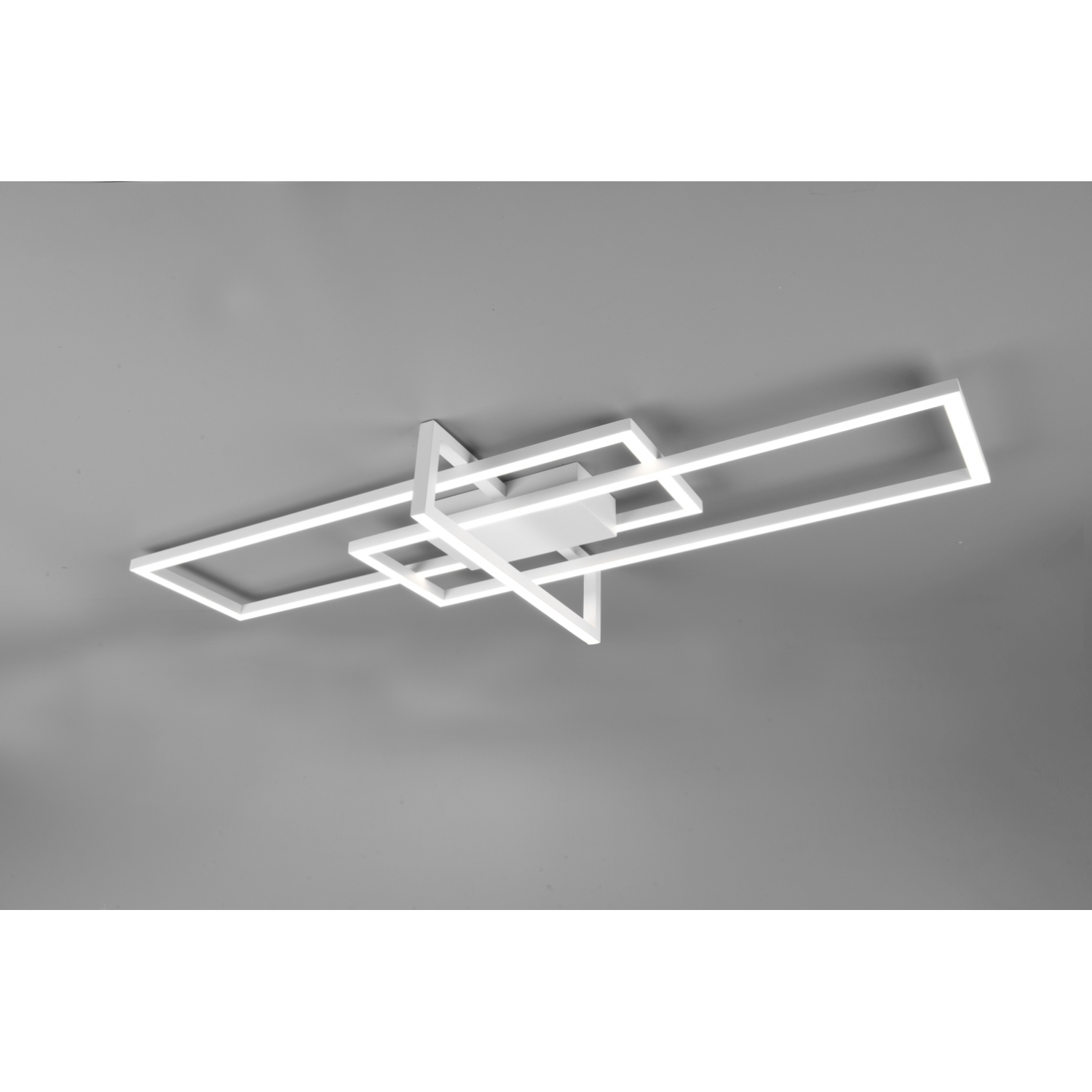Una lampada da soffitto bianca moderna con un design geometrico, contro un soffitto grigio.