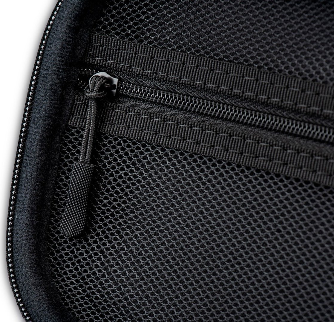 Zbliżenie czarnej siateczkowej torby na zamek błyskawiczny, pokazujące zamek i strukturę siatki.