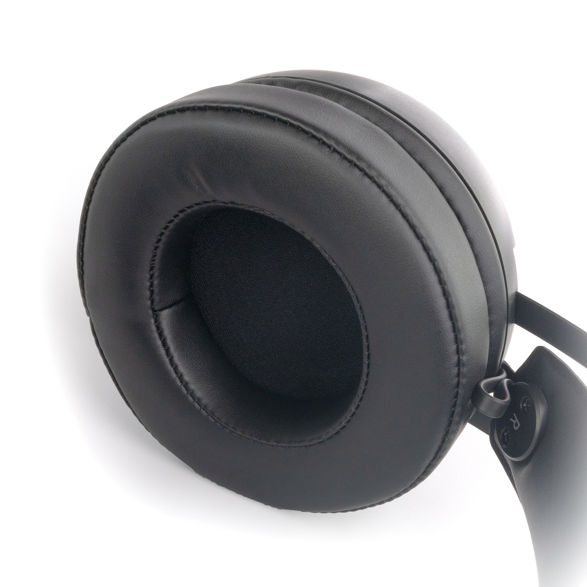 Zbliżenie czarnej nausznic słuchawek, skupiające się na miękkim, skóropodobnym materiale.