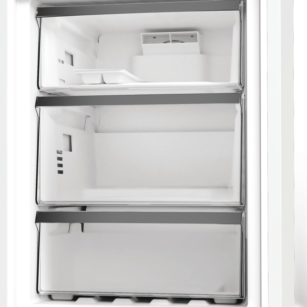 Dentro de un congelador de refrigerador con cajones transparentes, máquina de hielo en la parte superior.