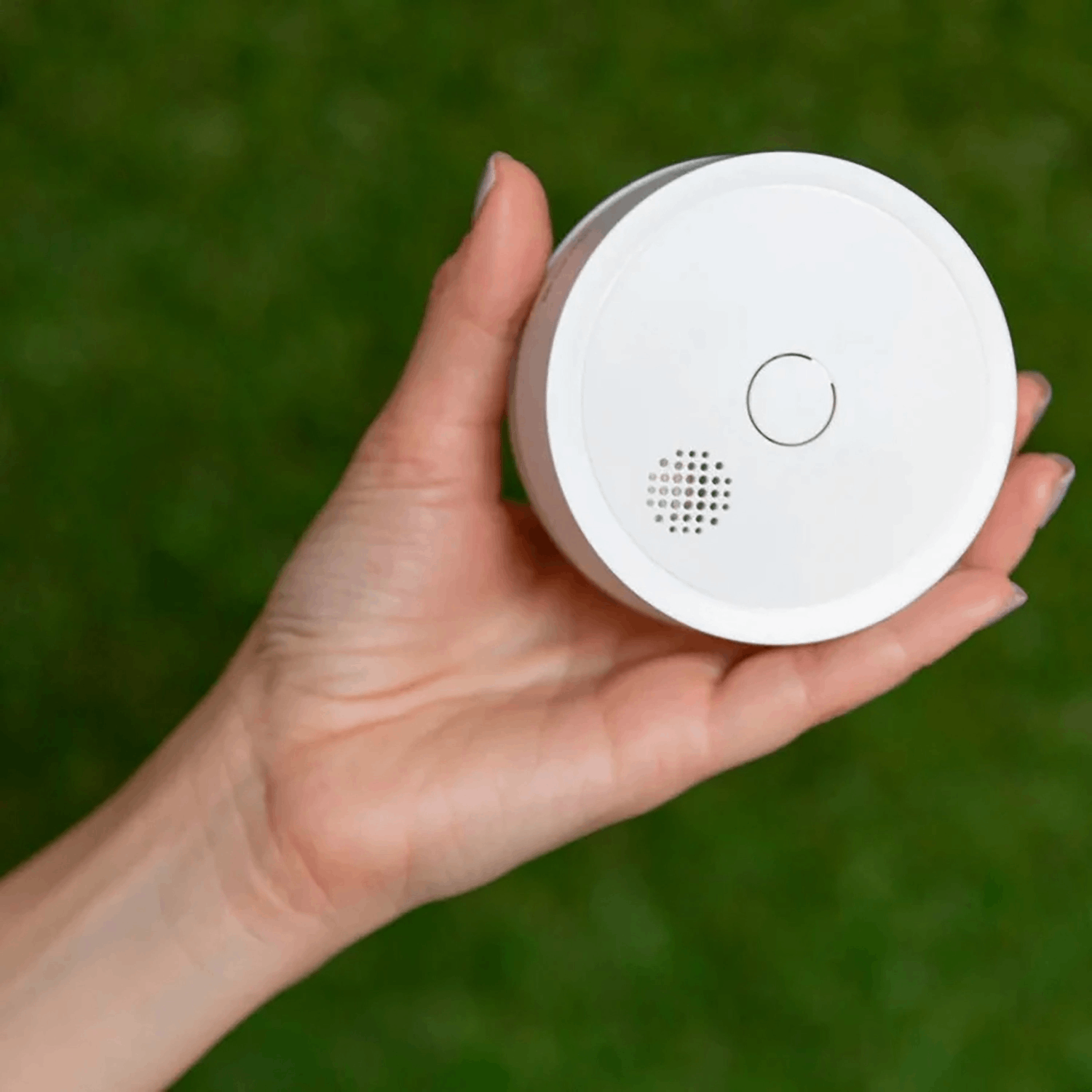 Detector de humo blanco en una mano abierta.