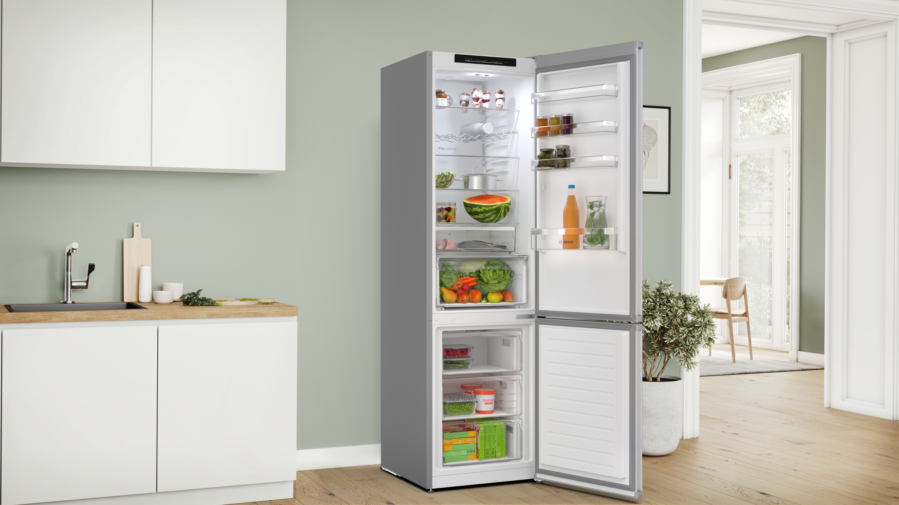 Geöffneter Kühlschrank in einer Küche. Gefüllt mit Lebensmitteln. Kühlschrank ist grau und weiß. Küchenumgebung.