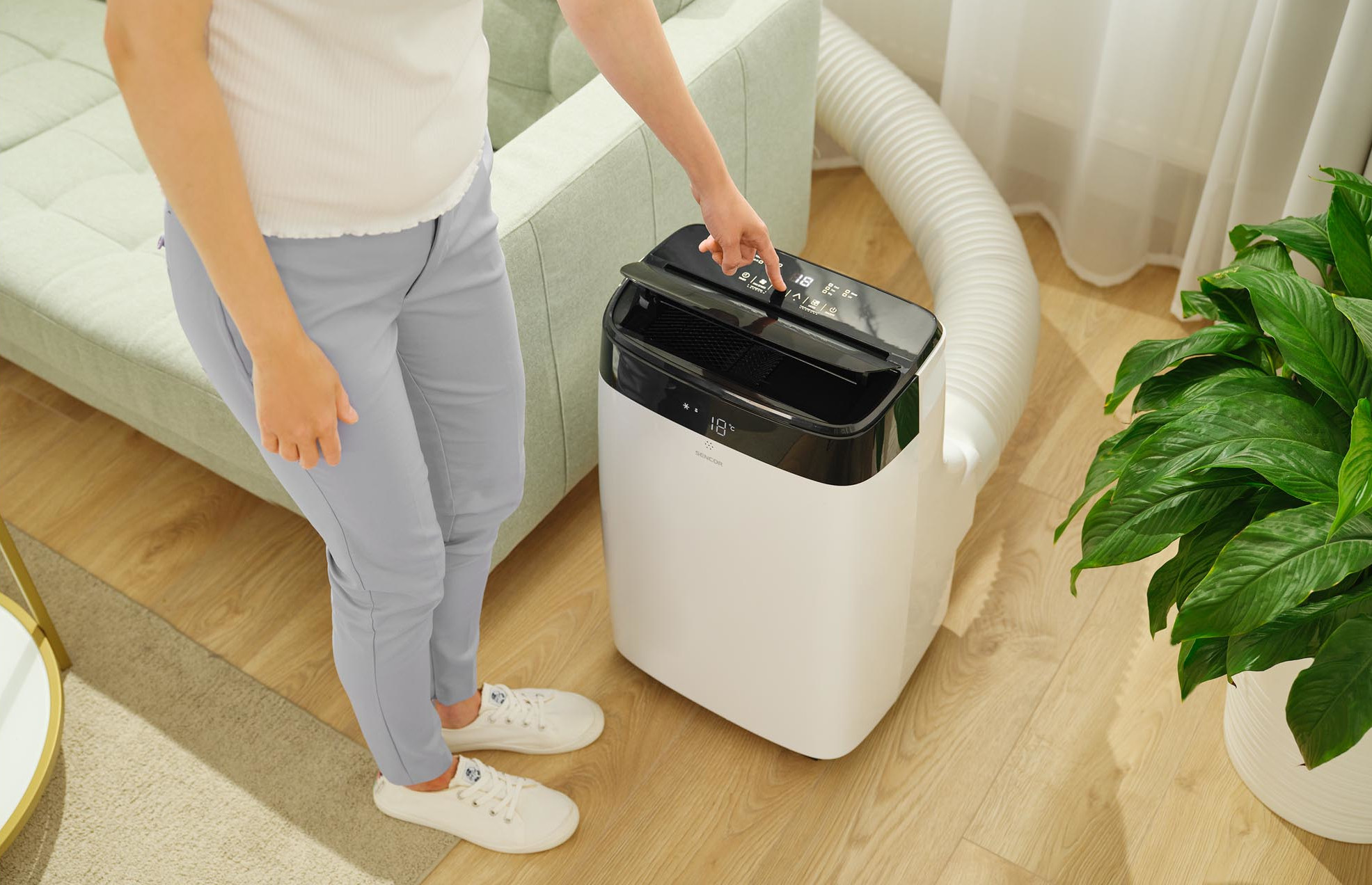 Kobieta obsługująca białą klimatyzację.