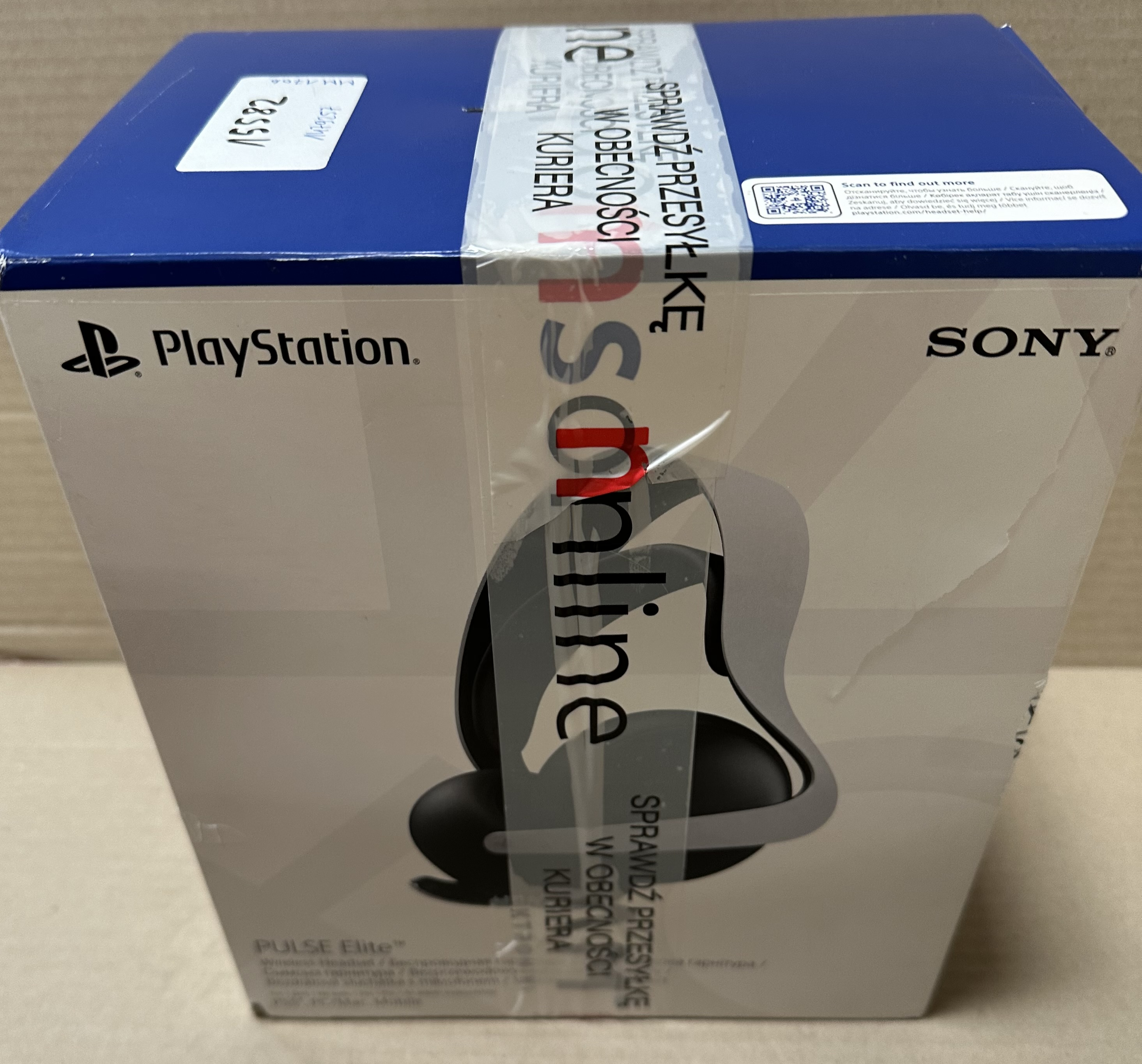 Niebieskie pudełko PlayStation zapieczętowane taśmą. Widoczny tekst w języku polskim i angielskim.
