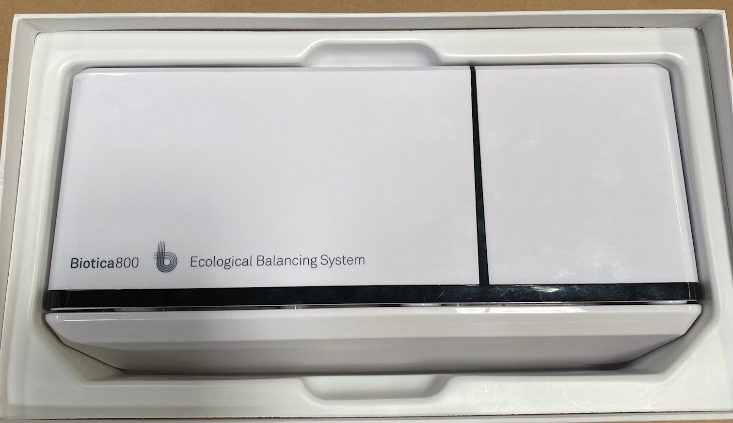 Białe prostokątne urządzenie w białym pudełku. Tekst na urządzeniu brzmi 'Biotica 800'.
