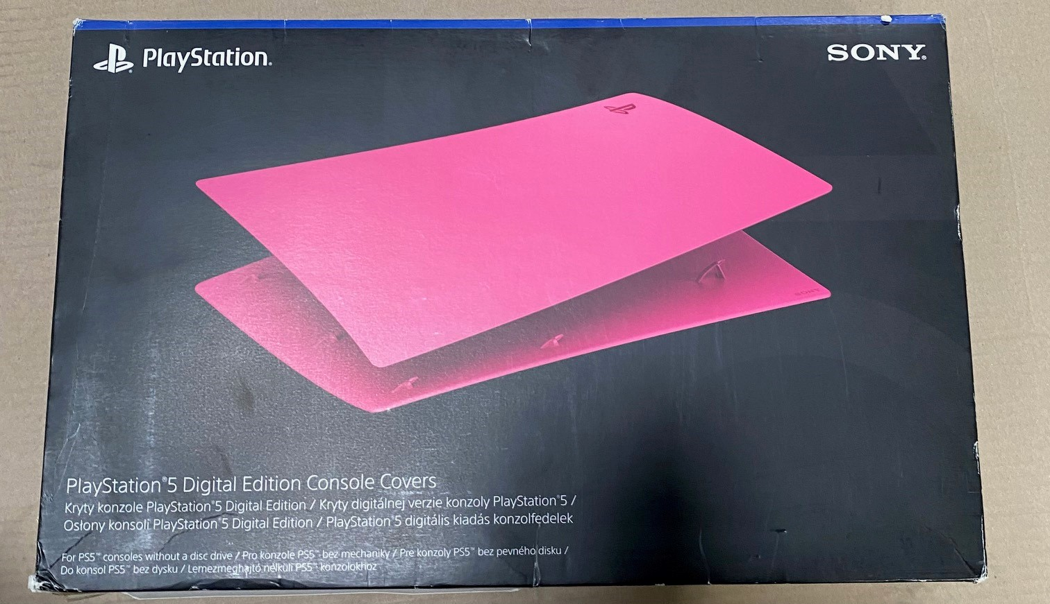 Osłony konsoli PlayStation 5 w pudełku. Różowy kolor. Czarne tło z tekstem.