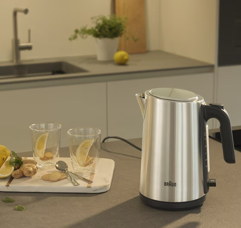 Czajnik ze stali nierdzewnej ze szklankami i cytryną.