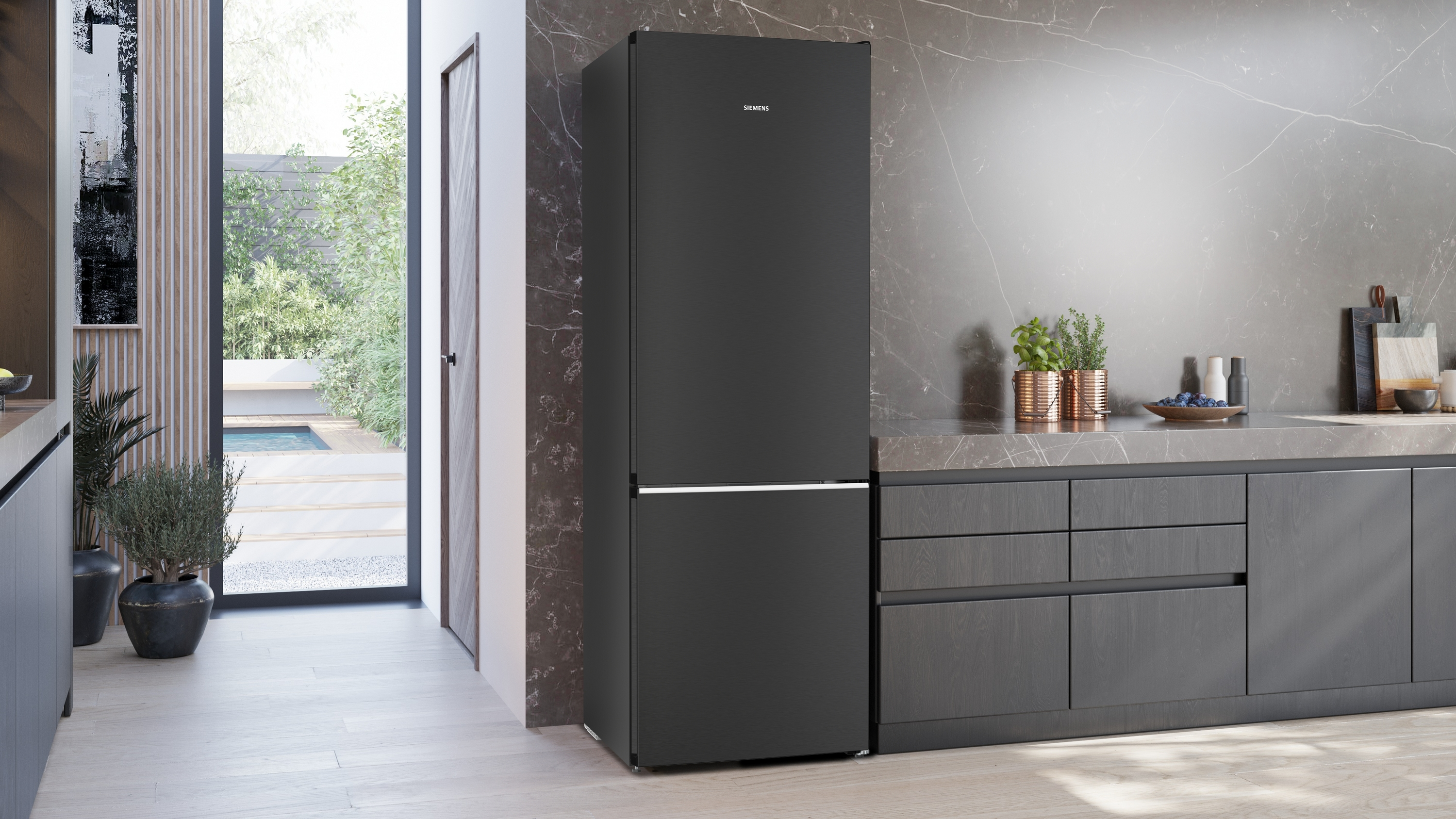 Schwarzer Siemens-Kühlschrank in einer modernen Küche. Akzente aus Edelstahl. Dunkelgraue Schränke und Arbeitsplatte.