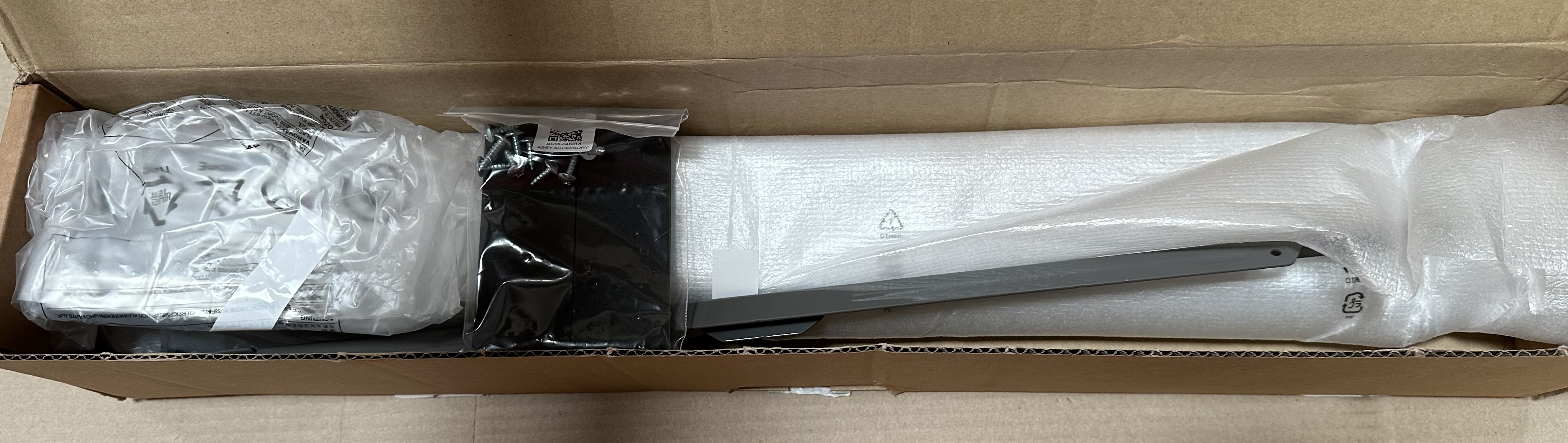 Zawartość otwartego kartonowego pudełka z materiałami opakowaniowymi i akcesoriami.