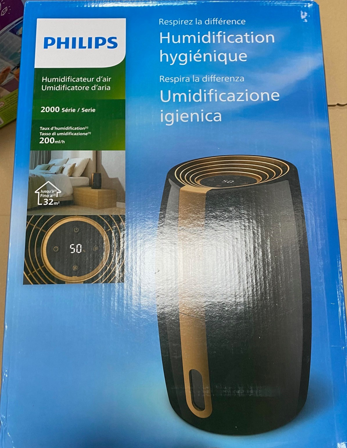 Pudełko nawilżacza. Czarno-złoty design, marka Philips. Tekst w wielu językach.