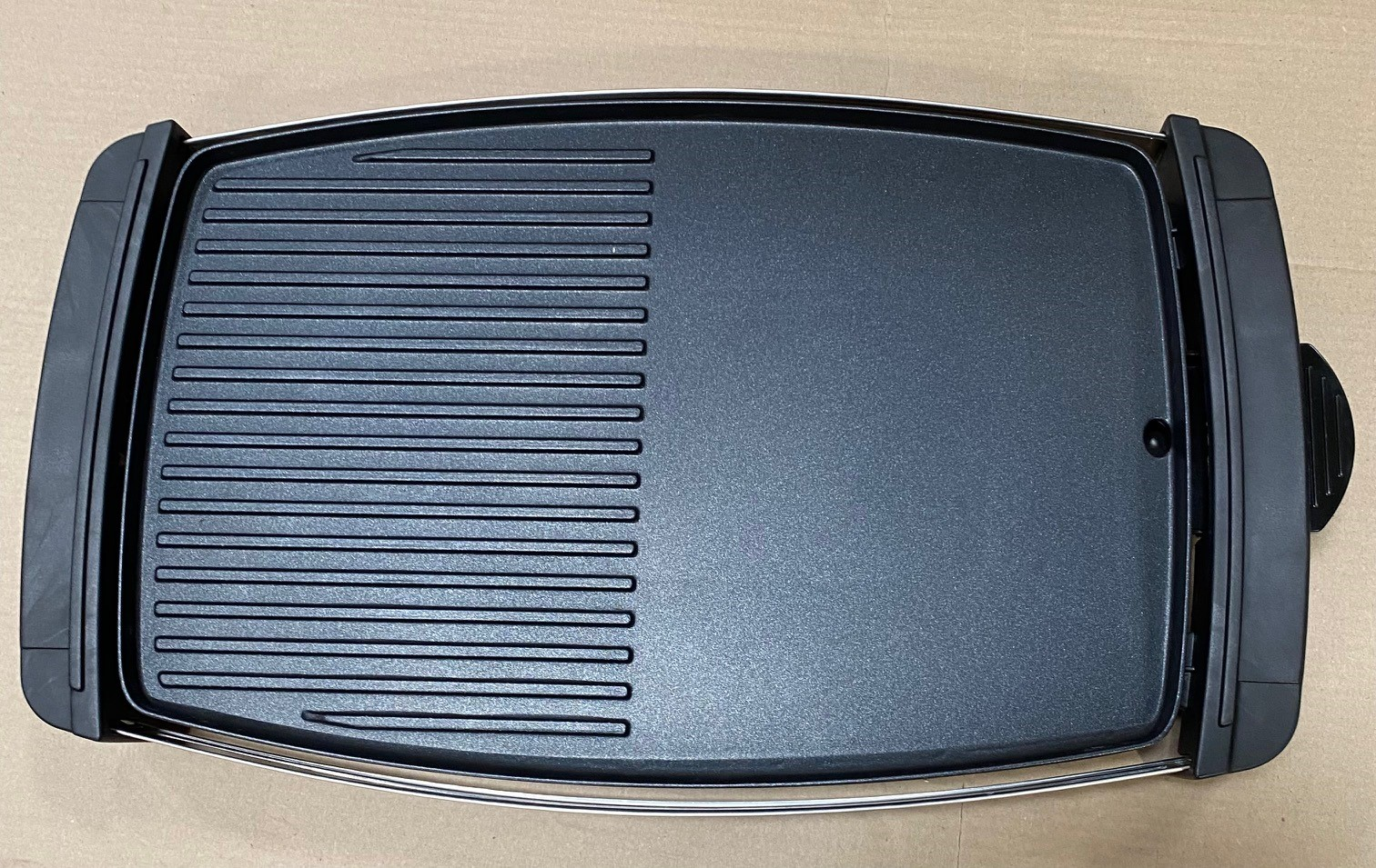 Grill elektryczny z płaską i żebrowaną powierzchnią do gotowania.