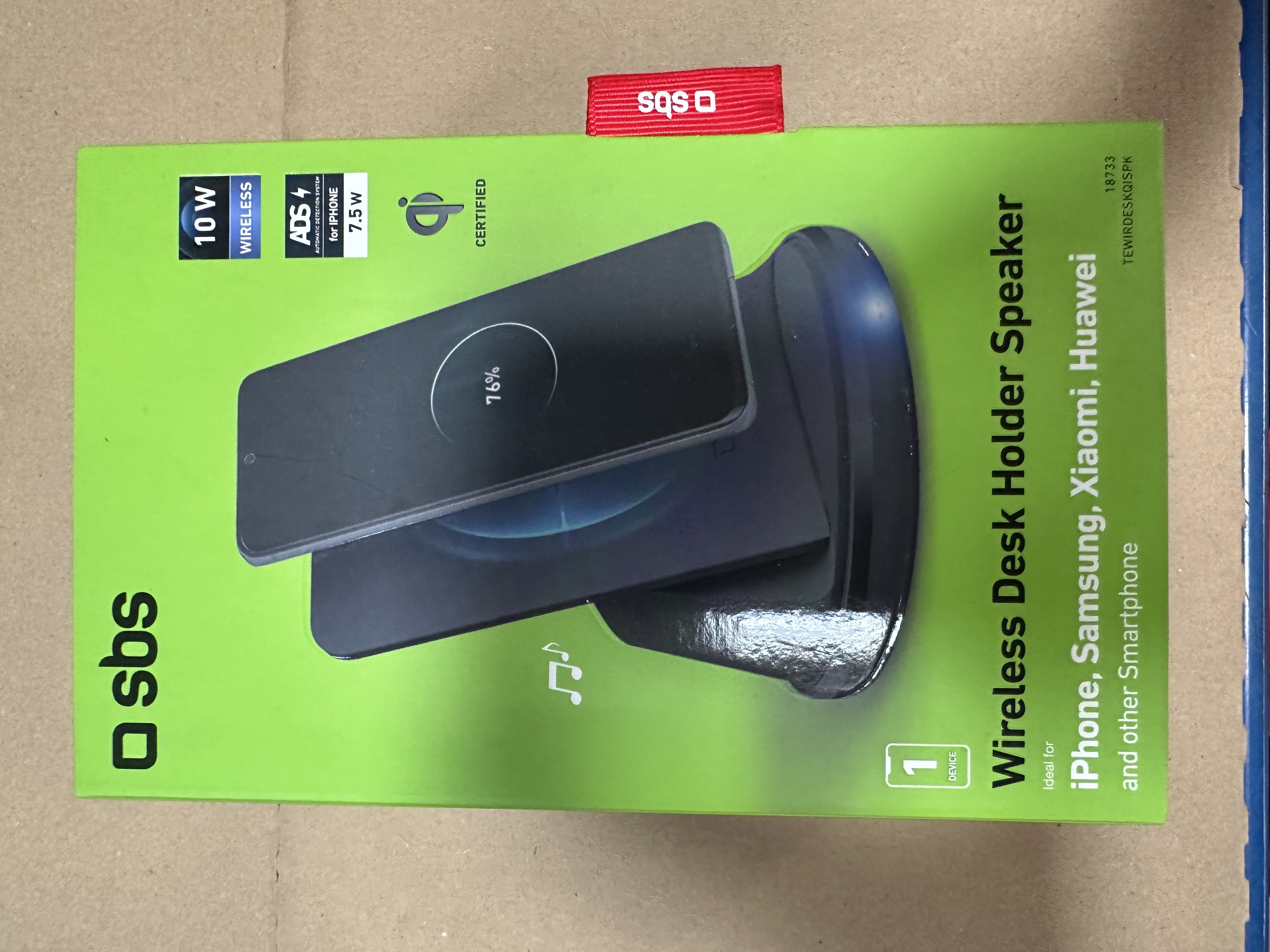 Zielone pudełko z głośnikiem Wireless Desk Holder. Telefon na górze pokazuje 76% naładowania. Pudełko ma logo sbs.