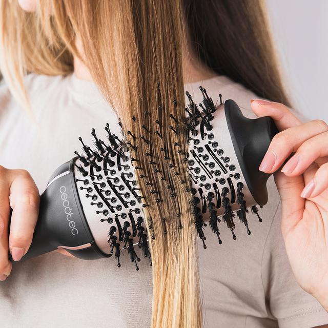 Kobieta używająca okrągłej szczotki do gorącego powietrza na włosach.