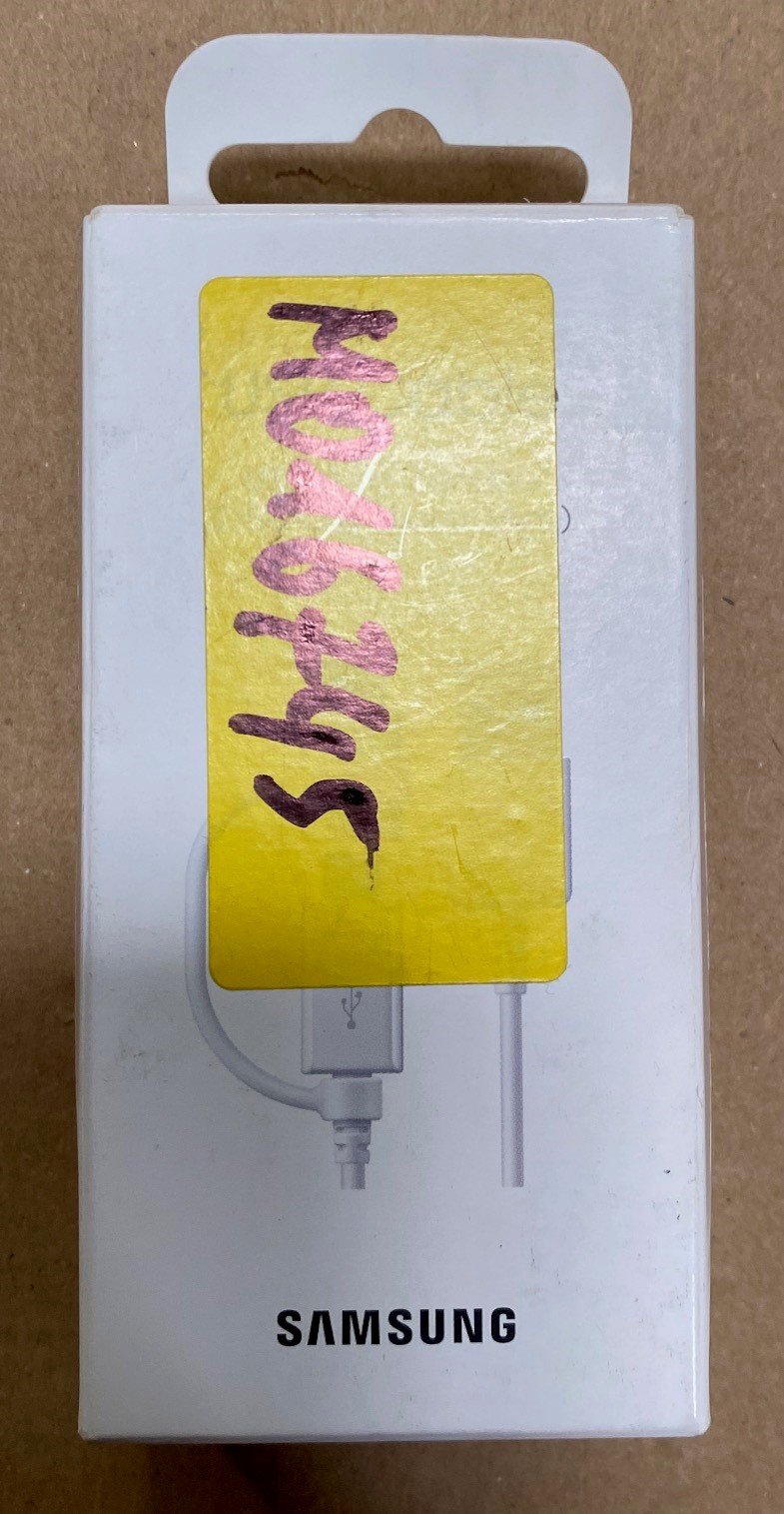 Białe pudełko ładowarki Samsung z żółtą naklejką i kablem USB.