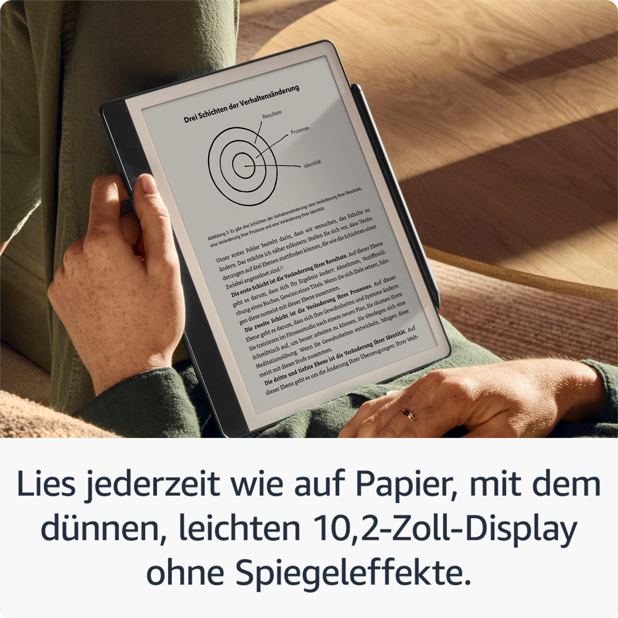 Person hält ein Kindle mit Text. Text auf Deutsch. Weißer Hintergrund. Ring an der Hand.