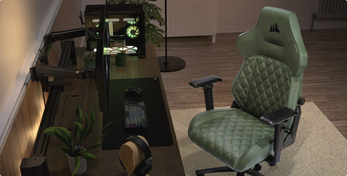 Konfiguracja do gier z zielonym fotelem do gier, biurkiem, monitorem i komputerem. Widoczny jest również zestaw słuchawkowy.