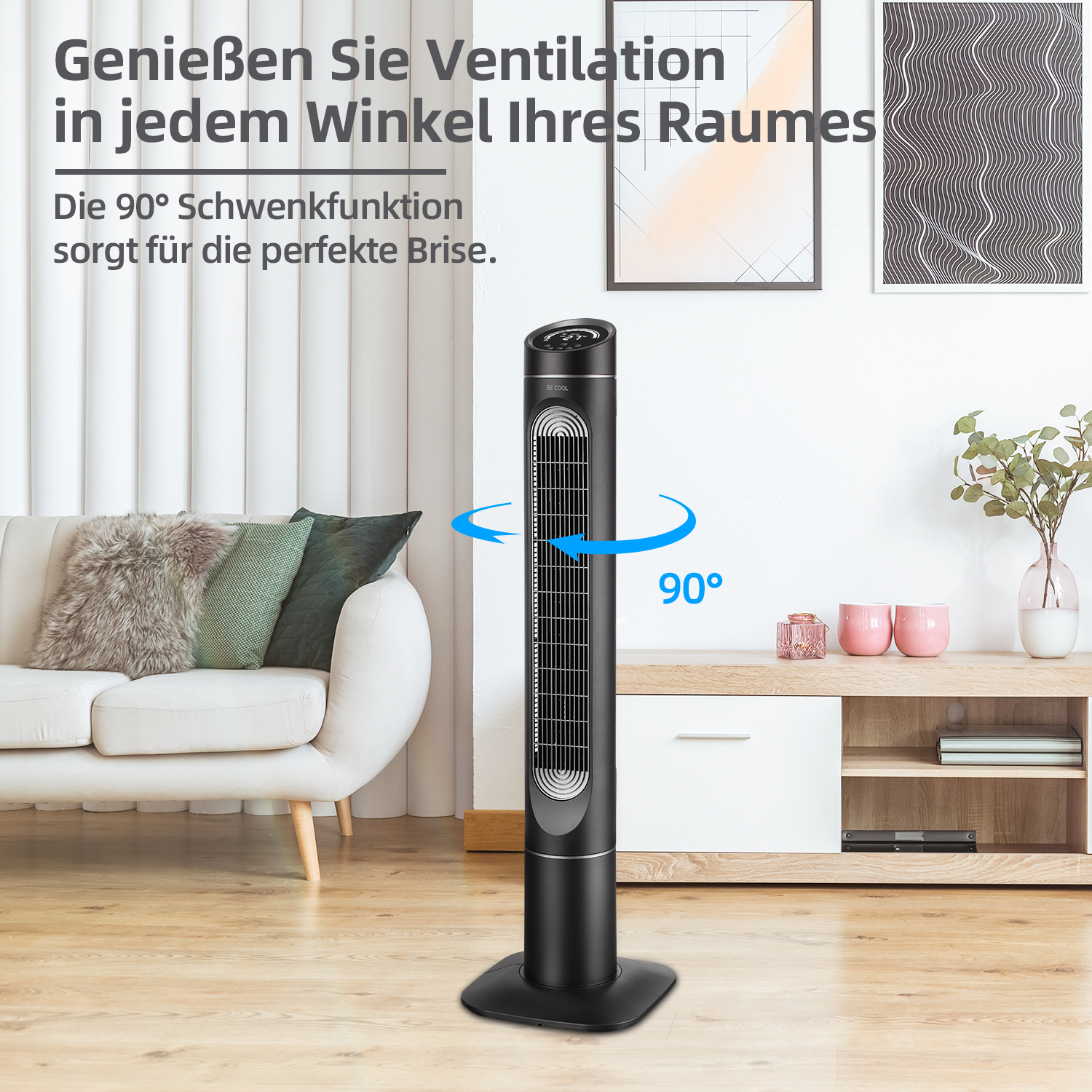 Schwarzer Turmventilator in einem Wohnzimmer mit weißem Sofa, zwei Bildern und einem Schrank.
